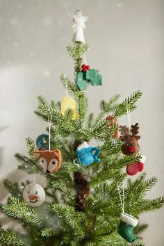 a small christmas tree with ornaments hanging from it