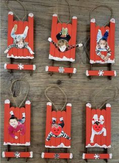 four wooden sleds with pictures on them and some string hanging from the top