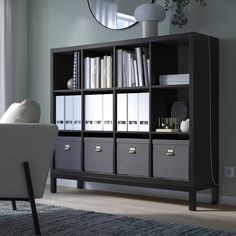 a living room with a chair and bookcase next to a mirror on the wall