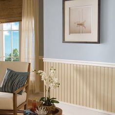 a living room with blue walls and white furniture in front of a window overlooking the ocean