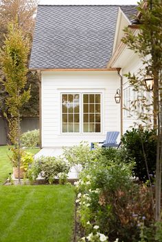 a small white house with a lawn in front