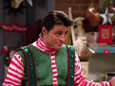 the young man is dressed up as santa clause in his christmas sweater and striped shirt