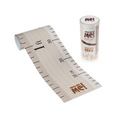 a measuring tape next to a tube of glue on a white background with the word me printed on it