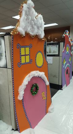 an office cubicle decorated like a house with santa's hat and wreath on the door