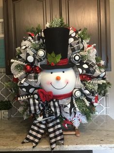 a christmas wreath with a snowman wearing a top hat