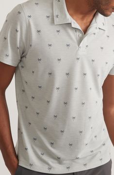 Palm trees punctuate the surface of this breathable short-sleeve polo shirt designed to wick away moisture and keep you cool. 28" length (size medium) Button half placket Spread collar Short sleeves Moisture-wicking fabric engineered for dryness and comfort 77% recycled polyester, 19% lyocell, 4% spandex Machine wash, tumble dry Imported