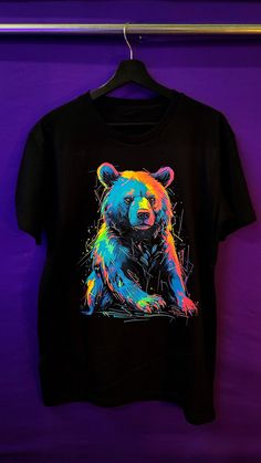 "Introducing the \"Beaming Bear: Exclusive Glow T-shirt\"  - a delightful addition to your wardrobe that will brighten your day with adorable charm! This captivating t-shirt showcases a cute and colorful bear design, perfect for those who adore bears and appreciate a splash of vibrant hues. 🎨 Captivating Prints: Our skilled artists have crafted an enchanting and lively bear print, ensuring that each shirt is a unique and exclusive piece of wearable art. 💡 Glow Under UV Light & In the Dark: Infuse your style with a touch of magic through the mesmerizing glowing features of this t-shirt. When exposed to UV light, the bear design illuminates with radiant colors, emanating a captivating glow that is sure to draw attention. Additionally, the design also glows in the dark, making it a delightf Playful Colorful Crew Neck T-shirt, Playful Rainbow Graphic Print T-shirt, Playful Multicolor Rainbow Print T-shirt, Playful Multicolor Crew Neck T-shirt, Colorful Playful Short Sleeve T-shirt, Multicolor Rainbow Print Short Sleeve T-shirt, Rainbow Print Short Sleeve T-shirt, Playful Multicolor Sublimation Print T-shirt, Playful Rainbow Print Crew Neck T-shirt