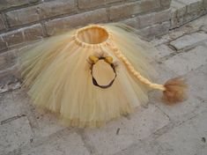 a yellow tutu skirt and hat on the ground