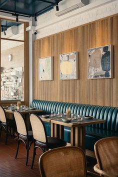 an empty restaurant with blue leather booths and wood paneling on the wall behind it