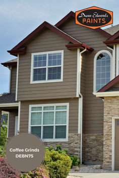 a coffee grinds sign on the side of a brown house with white trim and windows