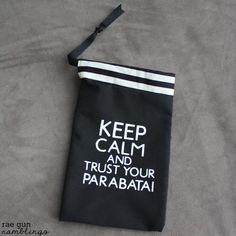 a black bag with white writing on it that says keep calm and trust your parabatia