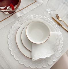 the place setting is ready to be served with goldware and white linen napkins