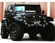 a black jeep parked in front of a brick building