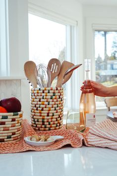 a kitchen counter with wooden utensils in a basket and plates on the table