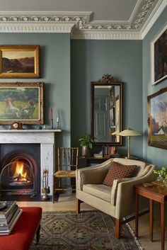 a living room filled with furniture and a fire place in front of a painting on the wall