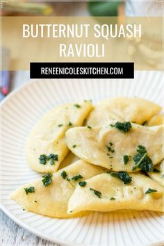 butternut squash ravioli on a white plate with spinach sprinkled on top