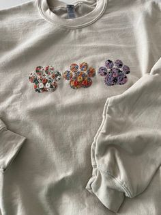 three different colored flowers on a white shirt