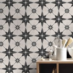 a black and white wallpaper with star designs on it is next to a shelf