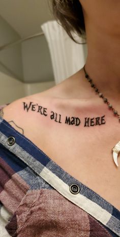 a woman's chest with the words we're all mad here written on it