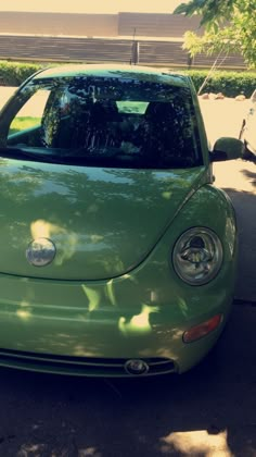 a green car is parked on the side of the road