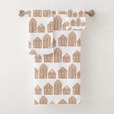 two towels with brown houses on them hanging from the side of a towel rack in front of a white wall