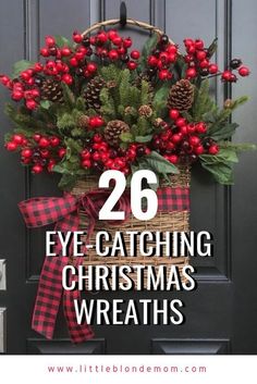 a christmas wreath with red berries and pine cones on it, in front of a black door