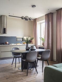 a dining room table and chairs in front of a window