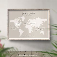 a white framed map with the names and date on it in front of a plant