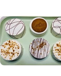 four desserts are arranged on a green tray