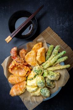 a plate filled with different types of food next to chopsticks