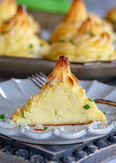 a slice of quiche on a plate with a fork in front of the rest