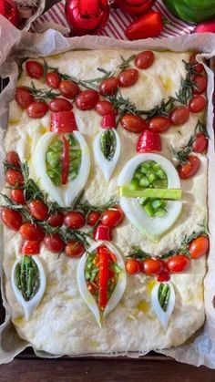 a pizza with tomatoes, cheese and other toppings on it in a baking pan