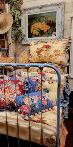 a bed with many pillows on top of it and a painting in the back ground