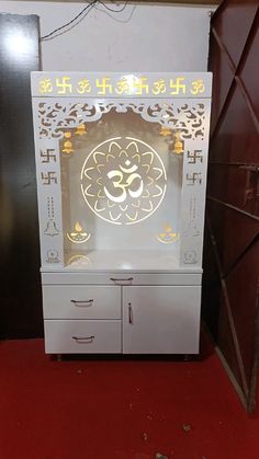 a white cabinet with an omen symbol on the front and gold trimmings