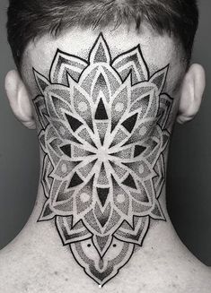 the back of a man's head with a tattoo on his neck and chest