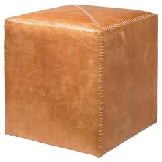 a square leather ottoman with stitching on the top and bottom, in light brown