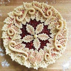 an intricately decorated pie crust on a wooden table with icing and sprinkles