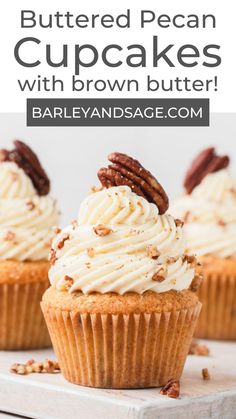 three cupcakes with white frosting and pecans on top