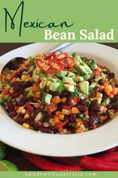 mexican bean salad with avocado and tomatoes in a white bowl