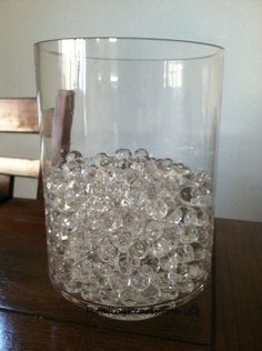 a glass filled with water sitting on top of a wooden table