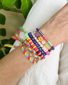 a woman wearing bracelets with colorful beads on her wrist