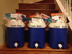 three blue coolers sitting on top of a wooden banister