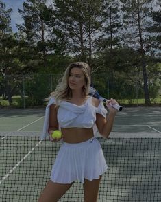 a woman holding a tennis racquet on top of a tennis court