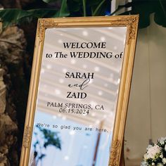 a welcome sign is placed in front of a mirror for the guests to take pictures