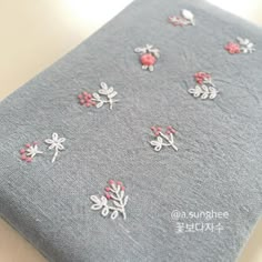 a close up of a cloth with small flowers on the side and red berries on the other side