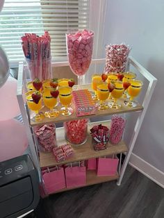 a candy bar with pink and yellow candies, lollipops, watermelon slices, strawberries, and more