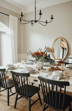 a dining room table is set with plates and place settings