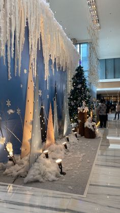 the lobby is decorated with snow and christmas trees