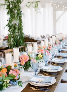 the table is set with flowers, candles and place settings for an elegant dinner party