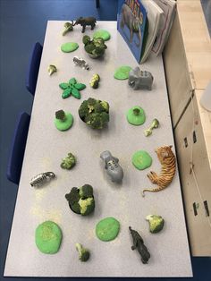 the table is covered with green and yellow play doughs, including broccoli